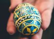 a person holding a painted egg in their hand