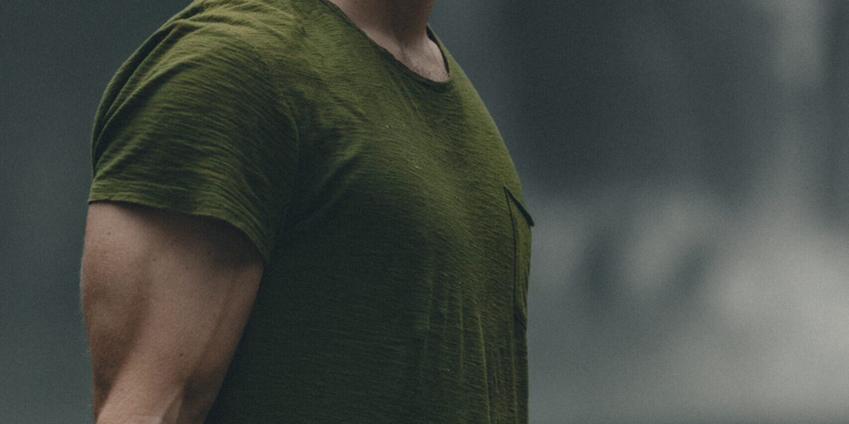 man wearing green crew-neck t-shirt looking upwards